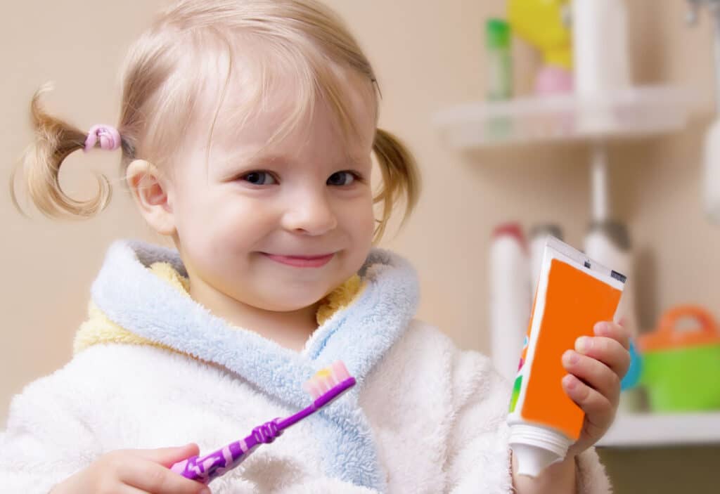 little girl with toothbrush and toothpaste