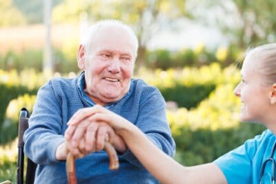 man in a wheelchair and caretaker smiling